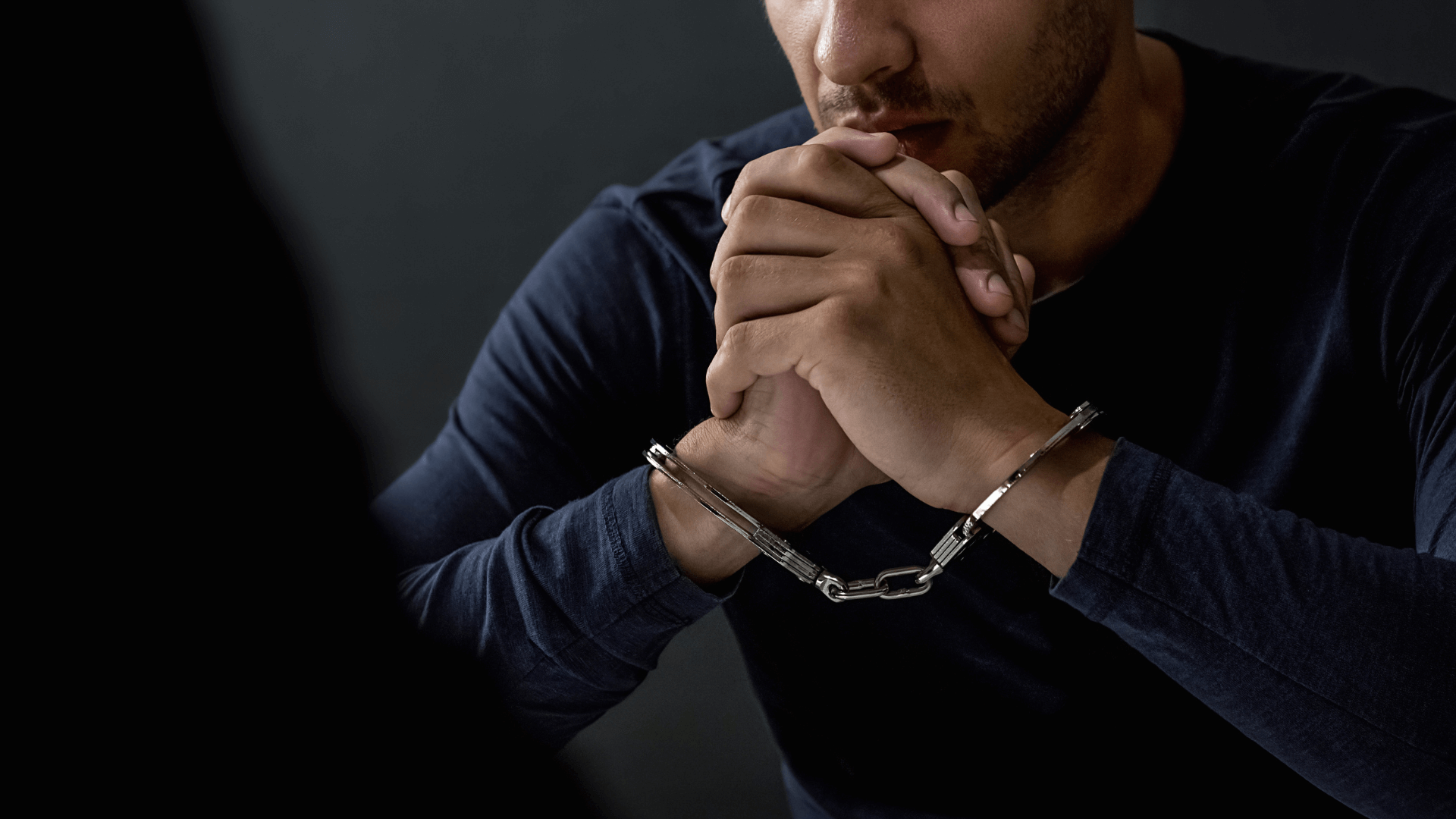 A man in handcuffs being interrogated 