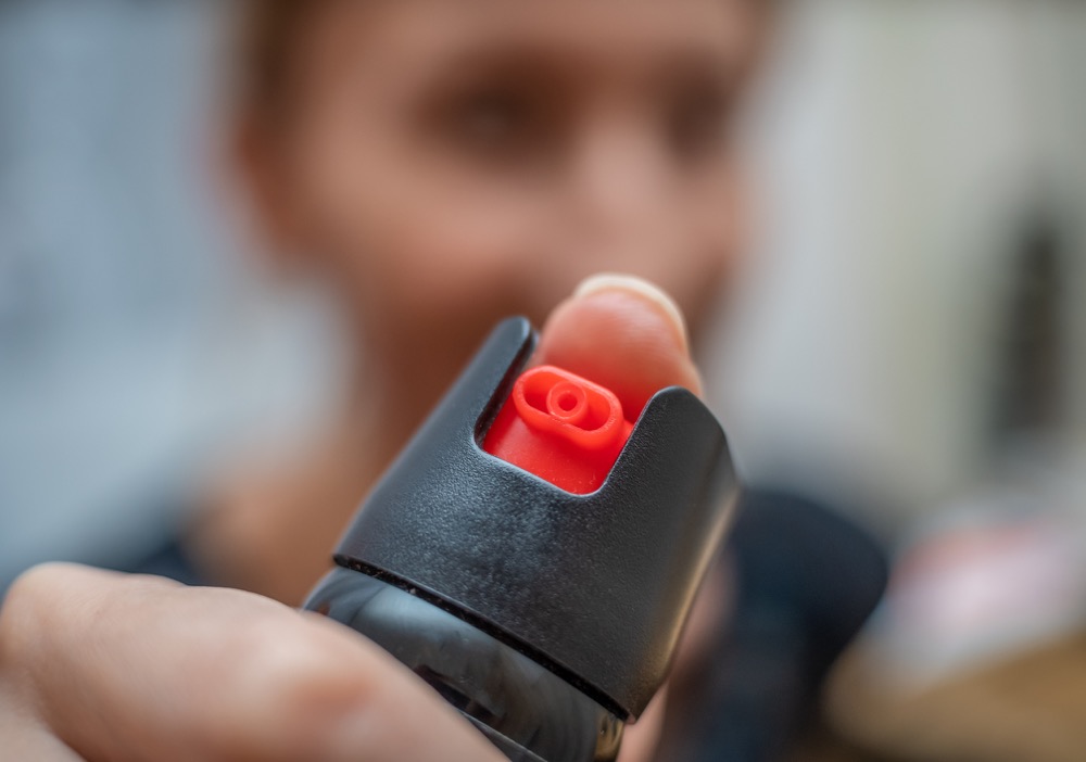 Close up of pepper spray in the girl's hand in the room stock photo