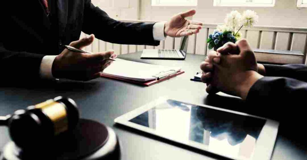 An attorney speaking with a client at his desk