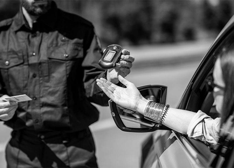 michigan police with breathalyzer michigan police officer handing driver breathalyzer device for DUI