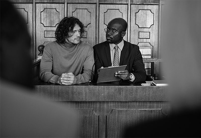 defense lawyer and client in court defense lawyer and his client sitting in michigan court for trial on DUI charges
