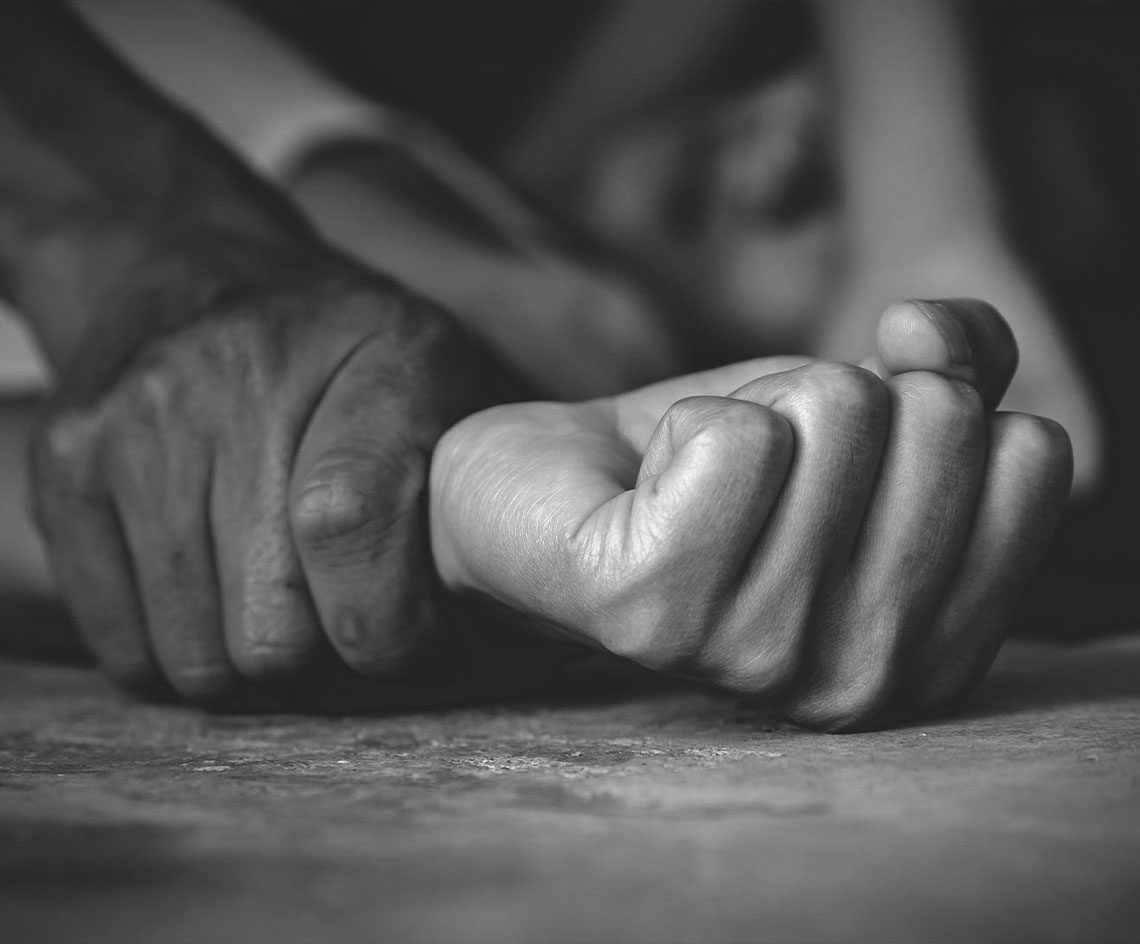 person being held down assault close up of a person's hands gripping and holding another person's wrists down on the ground assault