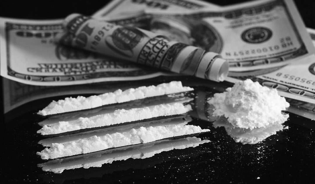 cocaine and money on table close up of lines of cocaine and money on a table after drug possession charges in michigan