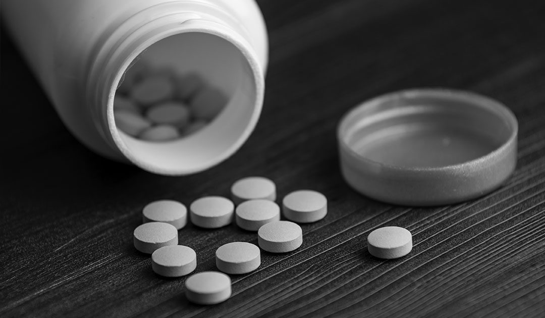 Prescription Drug Bottles on table close up of Prescription Drug bottle on table with pills spilling out