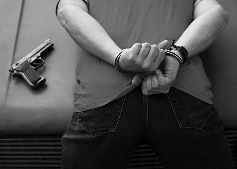 handcuffed man arrested with gun handcuffed man leaning over car hood with gun placed on hood arrested for carrying a concealed weapon