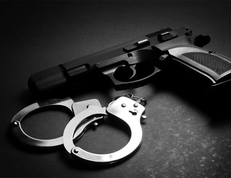 handcuffs and gun on table handcuffs and pistol placed on table