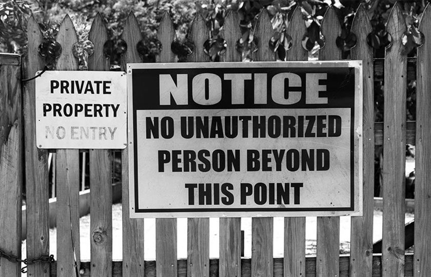 trespassing-warning-1 fence with trespassing sign for warning of vandalism charges in michigan